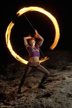 a woman holding a fire hoop in her hands