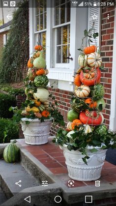 two white planters filled with lots of different types of vegetables