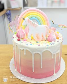 there is a cake decorated with unicorns and rainbows