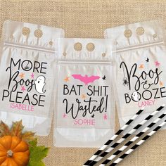 three bags with halloween sayings on them next to a striped paper straw and pumpkin