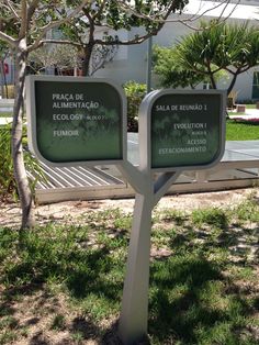 two signs are in the grass near a tree