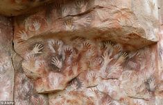 several hand prints on the rock wall