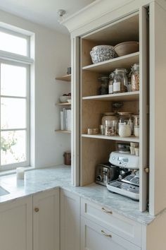 a kitchen with white cabinets and open shelves