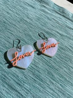 "Looking for the perfect accessory for the Eras tour? These one of a kind earrings are custom made for all of the Swifties out there! Available in iridescent acrylic with papaya letters and measuring 1.5\" across. Very lightweight and ideal for everyday wear. Finished with lead and nickel free hardware." Lover Earrings, Iridescent Acrylic, Eras Tour, Papaya, Hippie Boho, Jewelry Earrings Dangle, Etsy Earrings, Porter, Dangle Drop Earrings