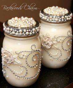 two white jars with pearls and flowers on them