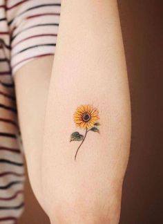 a small sunflower tattoo on the arm