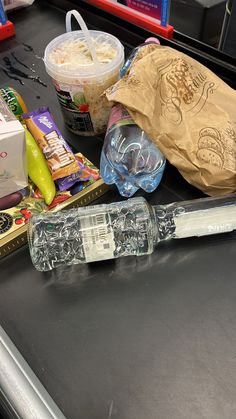 an assortment of food items sitting on a counter top next to a paper bag and plastic container