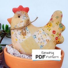 a stuffed chicken sitting in a potted planter next to a succulent