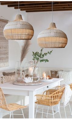 a white table with wicker chairs and hanging lights