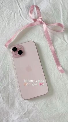 an iphone case with a pink ribbon attached to the back of it, sitting on top of a white sheet