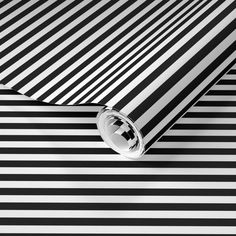 a black and white striped wallpaper with a circular hole in the center on it