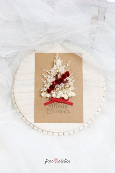 a christmas ornament is hanging on a piece of paper with red and white decorations