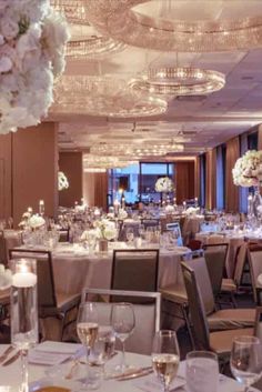 an elegantly decorated banquet room with chandeliers and flowers