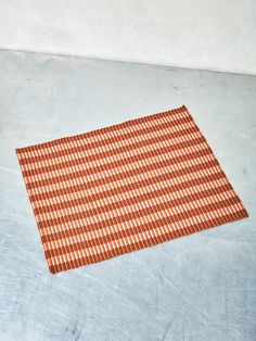 an orange and white checkered placemat on the floor