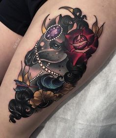 a woman's thigh with an animal and flowers tattoo design on her leg,