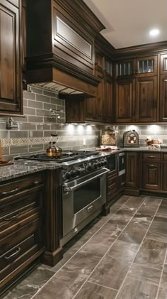 a large kitchen with wooden cabinets and stainless steel stove top oven in the center of the room