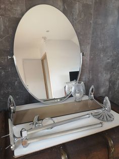 a mirror sitting on top of a table next to a chest with drawers underneath it