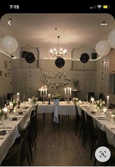 a dining room set up for a birthday party with candles and flowers on the table