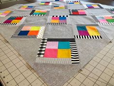 a patchwork quilt is laid out on the floor