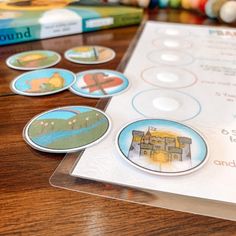 several different buttons on a table next to some books