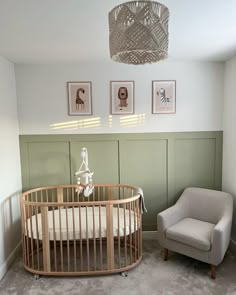 a baby's room with a crib, chair and pictures on the wall