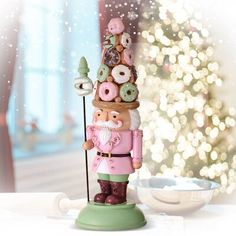 a nutcracker figurine stands next to a bowl of doughnuts