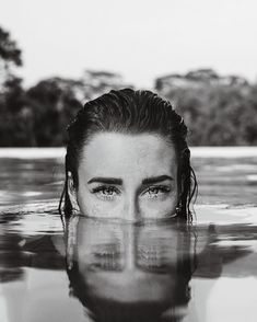 a woman is submerged in the water with her eyes closed