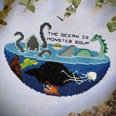 the ocean is monster soup cross - stitch pattern on white fabric with plants and rocks