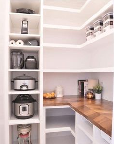 an organized pantry with white shelving and wooden counter tops