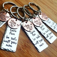 four key chains with different names on them sitting on a table together, one has a tag that says mom and the other has five tags attached to it