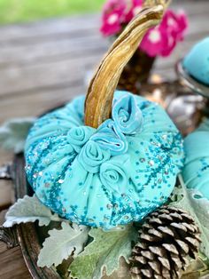 a basket filled with blue pumpkins sitting on top of a wooden table