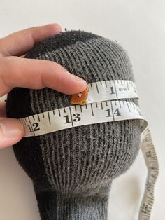 a person measuring their head with a tape measure