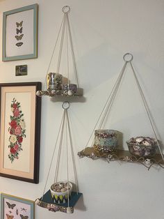 three hanging shelves with pictures on the wall