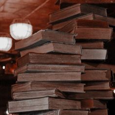 a stack of books sitting on top of each other in front of a light fixture