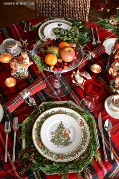 the table is set for christmas dinner with plates and silverware