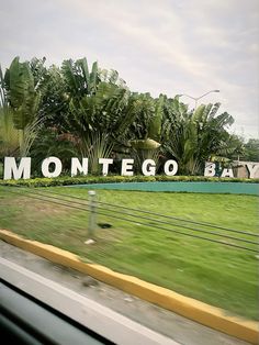 there is a sign that says montego bay in front of the grass and trees