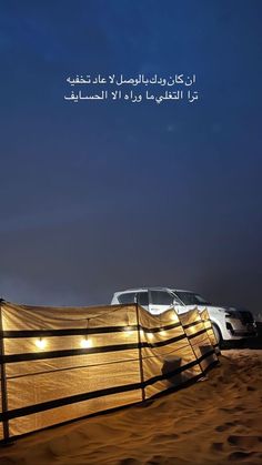 a car is parked in the sand behind a fence with lights on it's sides