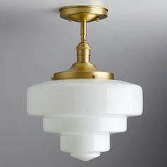 a white light hanging from a ceiling fixture in a room with gray walls and flooring