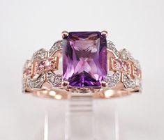 Rose Gold Diamond, Pink Tourmaline and Amethyst Engagement Ring. This ring is set in the center with one genuine Emerald Cut Amethyst, eight Round Pink Tourmaline and thirty-two natural Round Brilliant Diamonds. The Amethyst measures 9 X 7 mm and weighs 2 carats. The Pink Tourmaline combine to a total weight of .10 carat. The diamonds in this ring are H color, SI/I1 in clarity and weigh a total of .15 carat. This ring is 10KT Rose Gold, weighs 3.5 grams and is a finger size 7 1/4, which can be resized (please inquire about sizing with the finger size you need). This ring will be accompanied by an appraisal written by a GIA Certified Diamond Grader with the retail replacement value of $1,495.00. I will ship this ring promptly in a beautiful gift box. Amethyst Engagement Ring, Amethyst Ring Engagement, Engagement Ring Diamond, Rose Gold Diamonds, Ring Diamond, Beautiful Gift Boxes, Everyday Jewelry, Pink Tourmaline, Emerald Cut