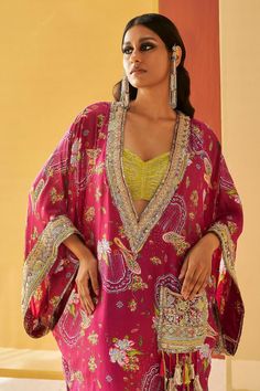 Pink kaftan featuring a deep V neck, flared sleeves, and all-over floral print. Paired with coordinating floral print joggers and a lime green bustier., Fit: Relaxed Traditional Festive Maxi Length Kimono, Festive Traditional Maxi Length Kimono, Silk Kaftan With Printed Motifs In Saree Shape, Traditional Printed Sets In Maxi Length, Silk Kaftan With Printed Motifs Shaped Like A Saree, Traditional Kaftan With Printed Motifs For Weddings, Traditional Printed Sets With Maxi Length, Silk Kaftan With Printed Motifs For Wedding, Navratri Silk Kaftan With Printed Motifs