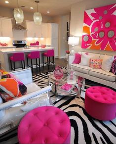 a living room filled with lots of furniture and pink accents on the walls, along with zebra print rugs