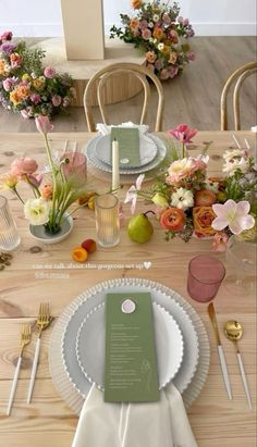 the table is set with flowers and place settings