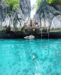 the water is crystal blue and clear, with steps leading to an island in the background