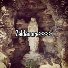 a statue with the word zeldacore above it in front of a cave