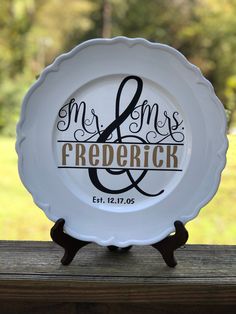 a white plate with the words mr and mrs on it sitting on top of a wooden table