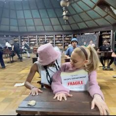 two people sitting at a table in a library