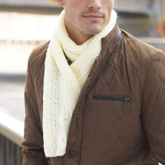 a man wearing a brown jacket and white scarf