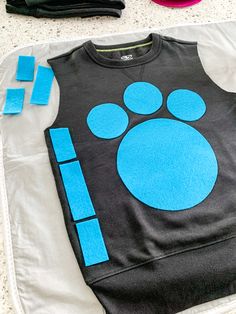 a black shirt with blue paw prints on the front and back, sitting on a table