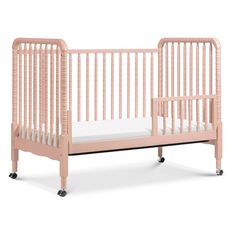 a pink crib with white sheets on the bottom and side rails, sitting against a white background