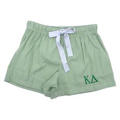 a green and white striped shorts with the letter k on it's front pocket